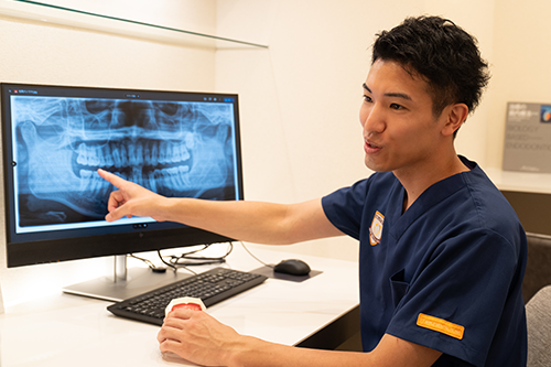 患者へ説明するアップル歯科の歯科医師